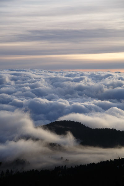 Des nuages enveloppent les sommets des montagnes alpines au coucher du soleil